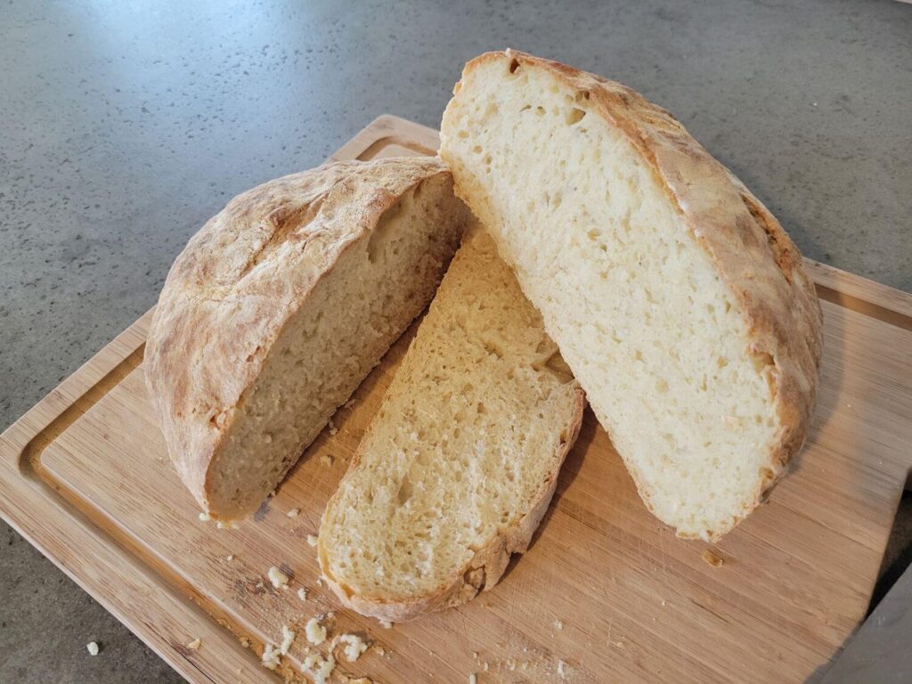 A loaf of homemade bread sits on a cutting board