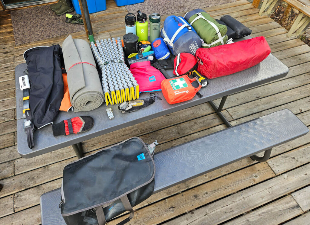 Paddling gear is is organized on a picnic table